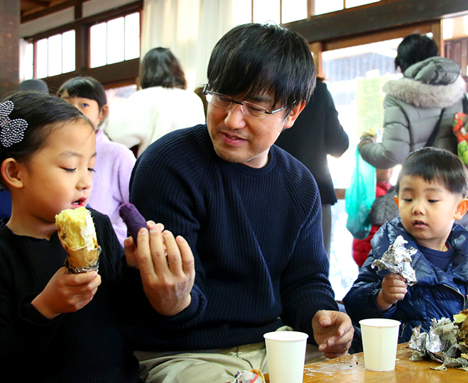 焼きいもを手にする親子
